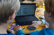 Zwei Kinder experimentieren am Computer mit Stahlwolle
