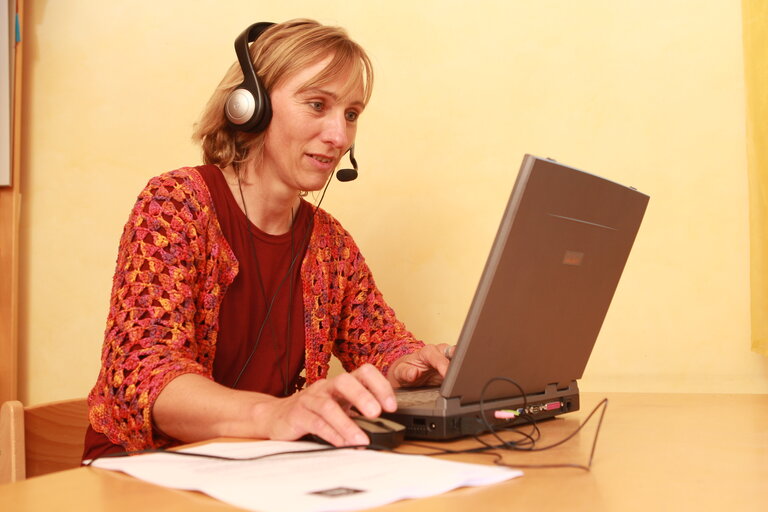 Frau am Computer mit Headset 