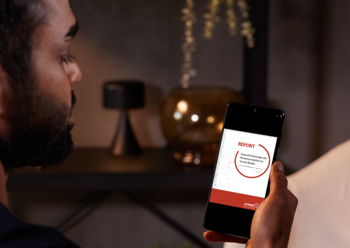 Eine Person, die auf ihrem Smartphone den Bericht über sexuell belästigende Kommunikation auf Social Media von jugendschutz.net liest.