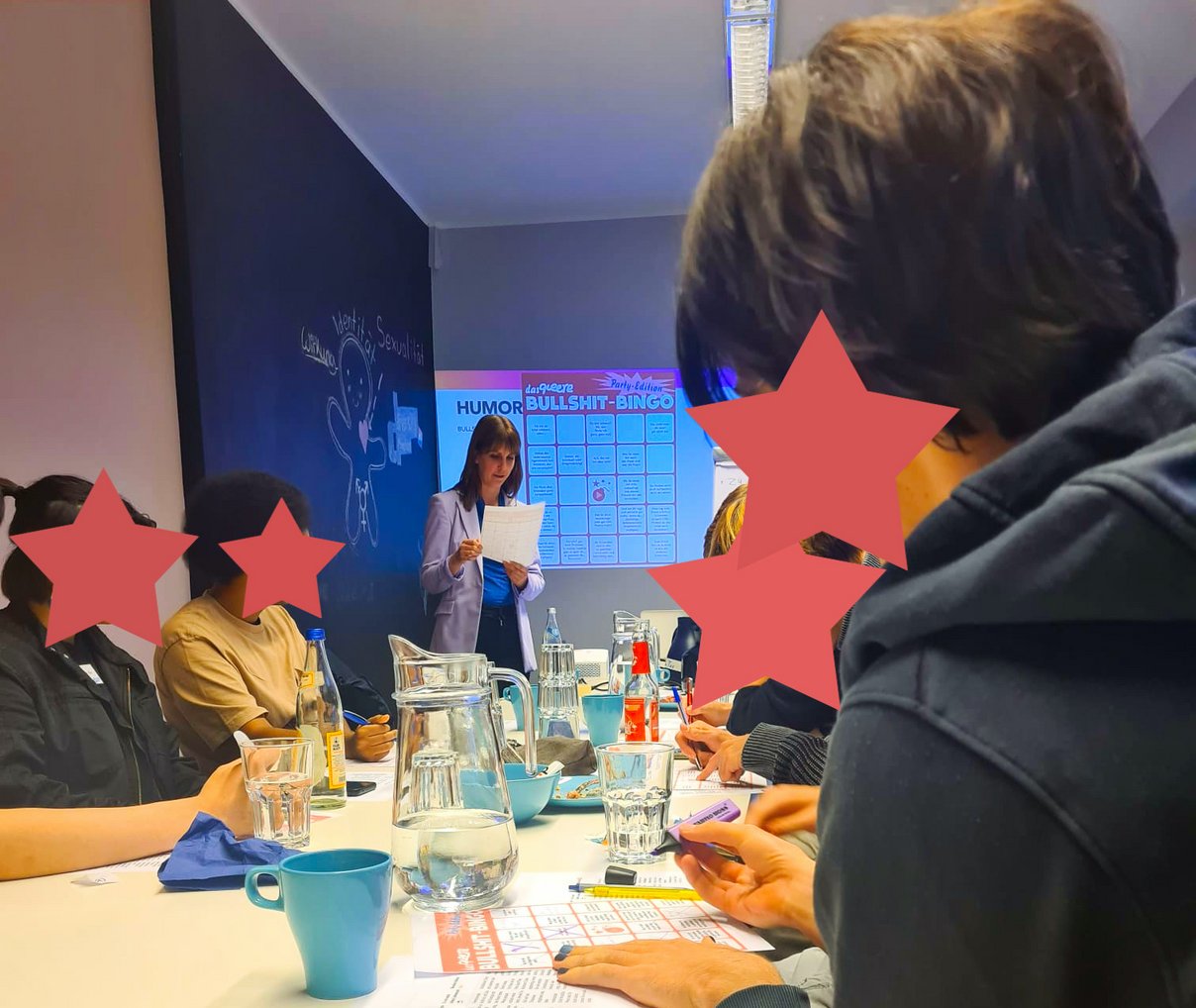 Personen, die an einem Tisch sitzen und an einem Bingospiel teilnehmen.