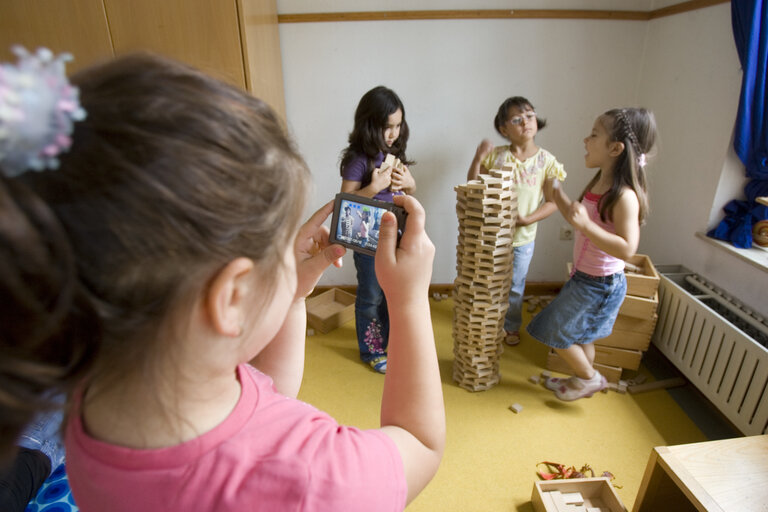 Kinder fotografieren einen Turm aus Holzsteinen 