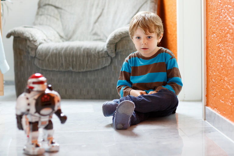 Kind spielt mit Roboter 
