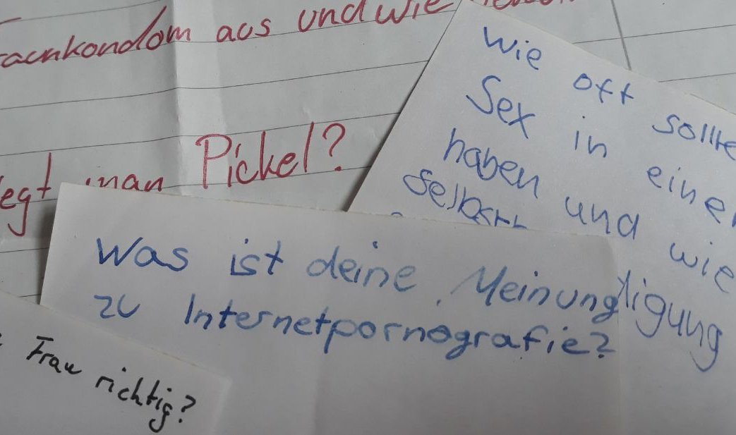 Fragen, die auf mehreren Papierblättern stehen.