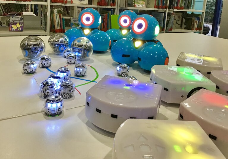 Kleine Lernroboter, die auf einer glatten Oberfläche stehen.