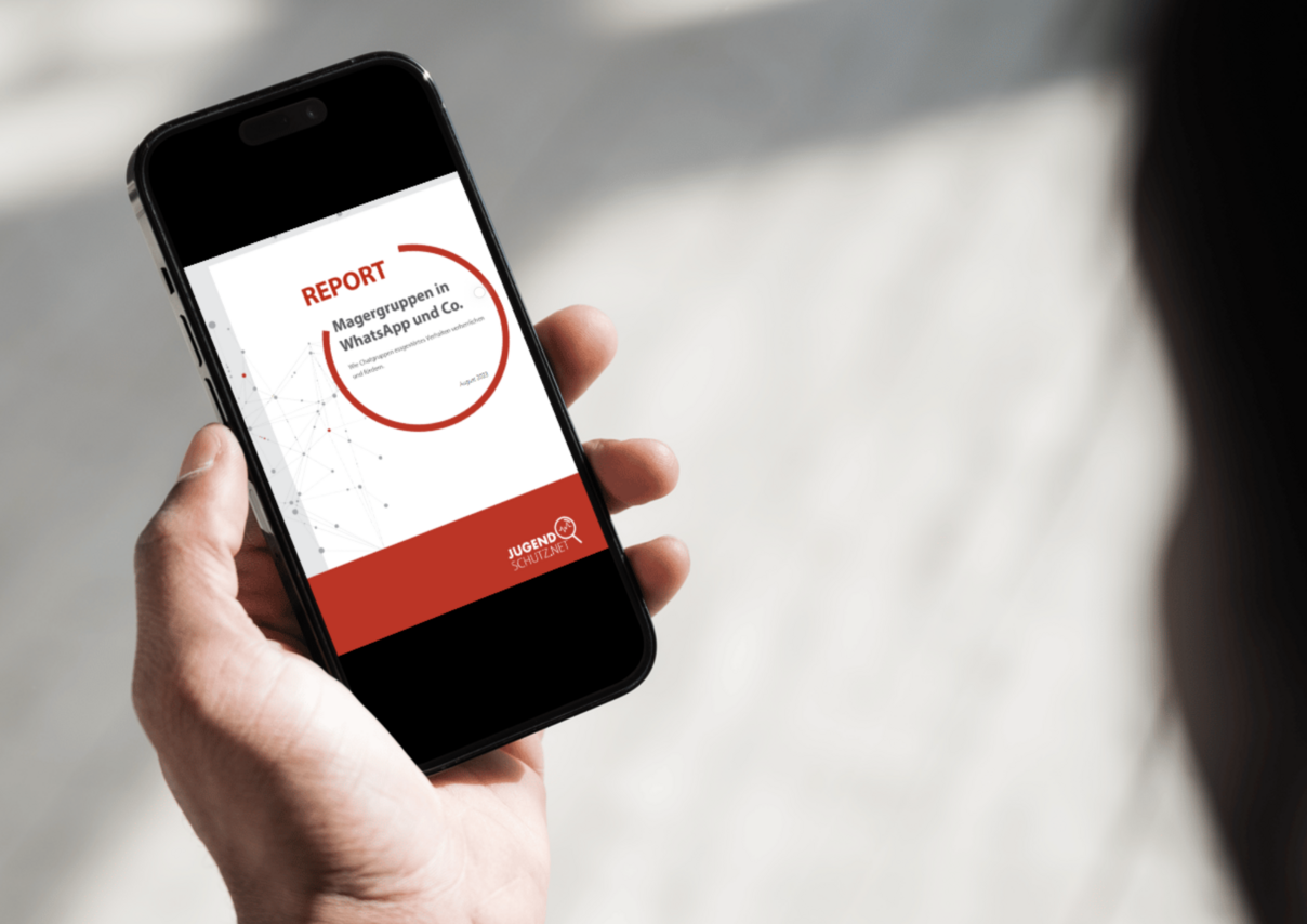 Eine Person, die auf ein Smartphone schaut, welches sie in der Hand hält.