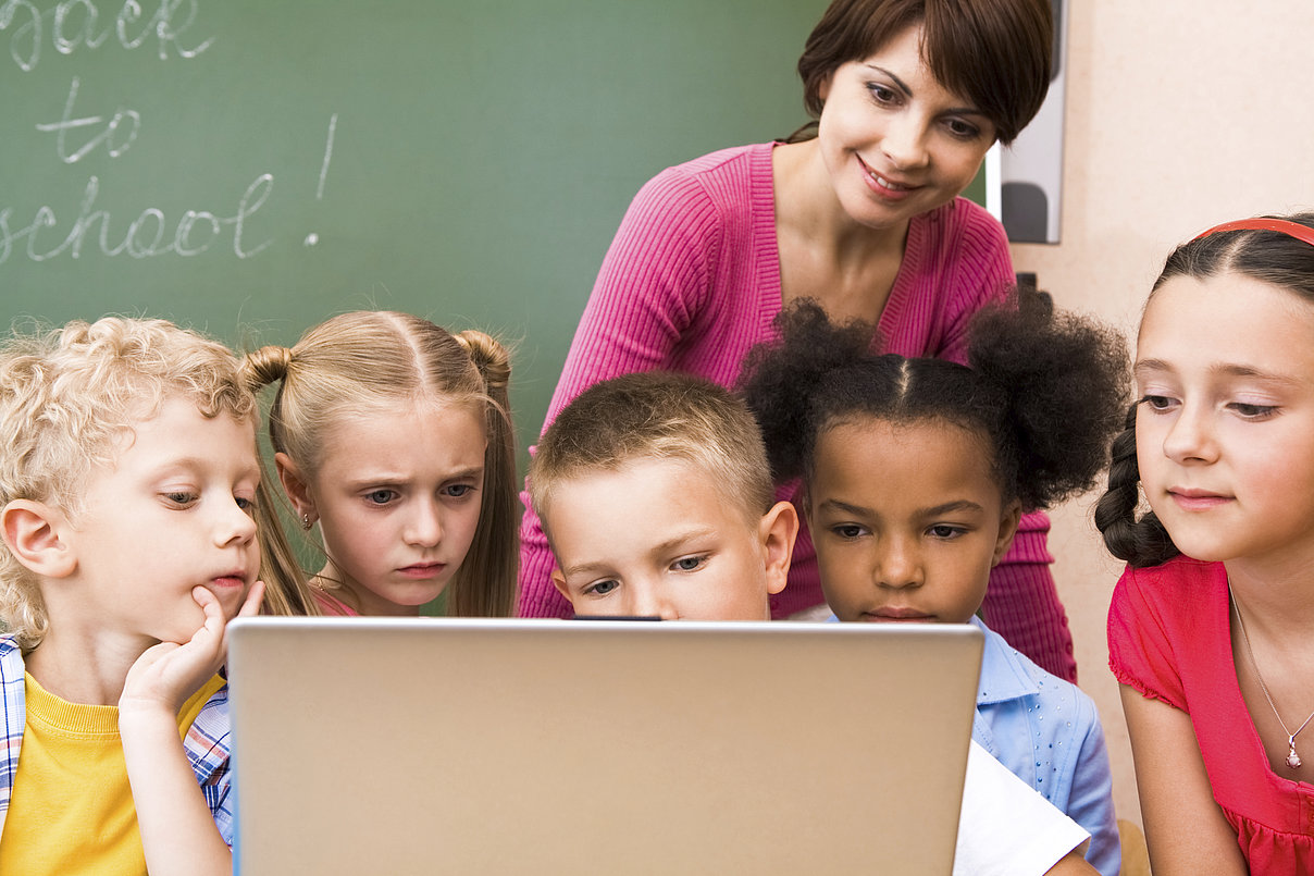 ThinkstockPhotos-118304405_Copyright_shironosov.jpg Eine Lehrerin mit Schülern am Laptop