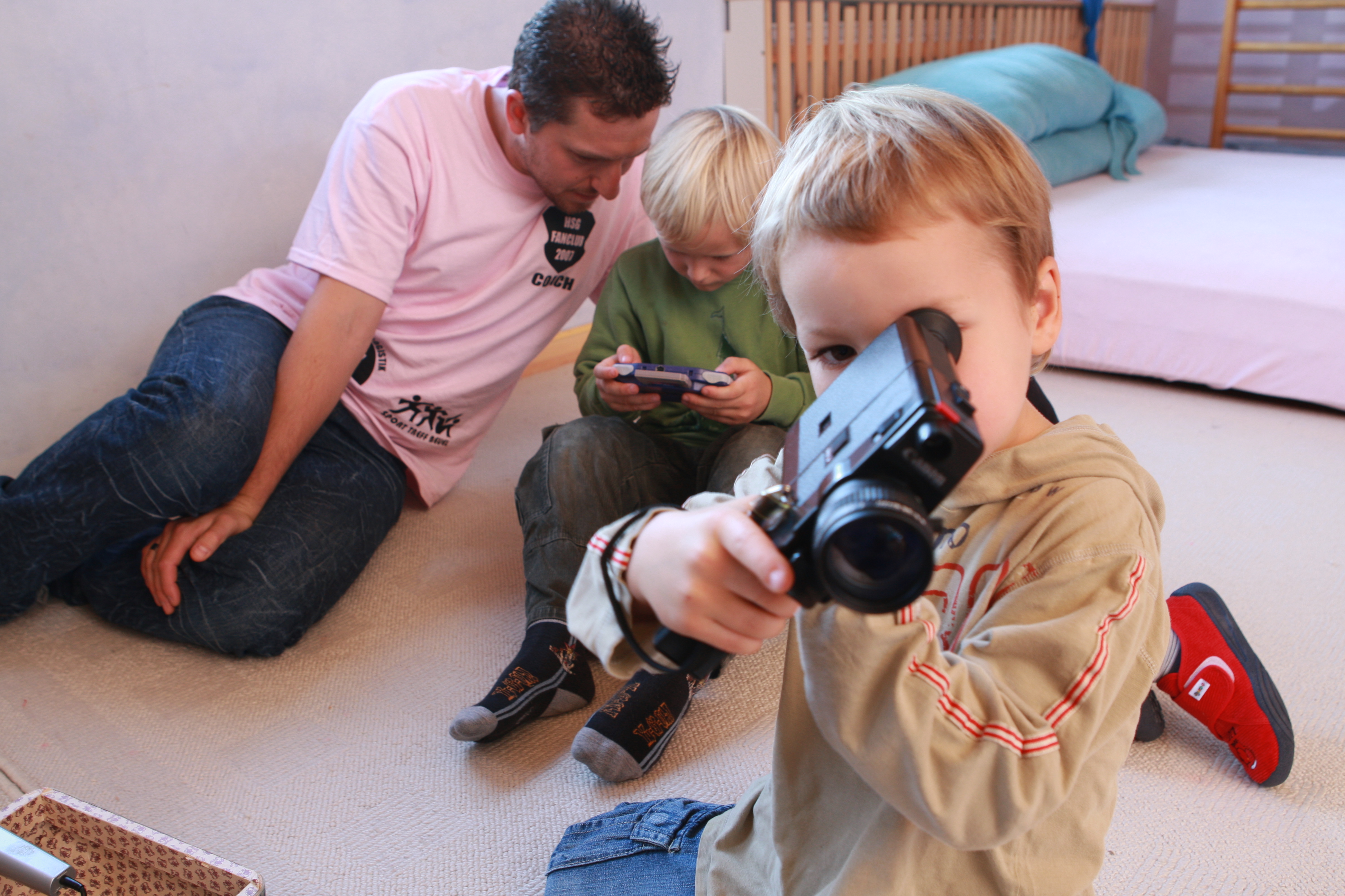 Kind mit Kamera und Telespiel und Erzieher 