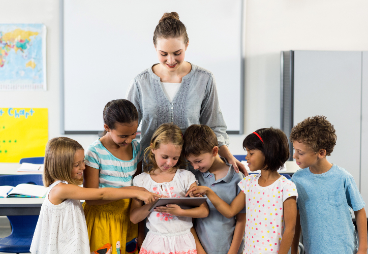 Frau mit Tablet und Kindern in der Schule