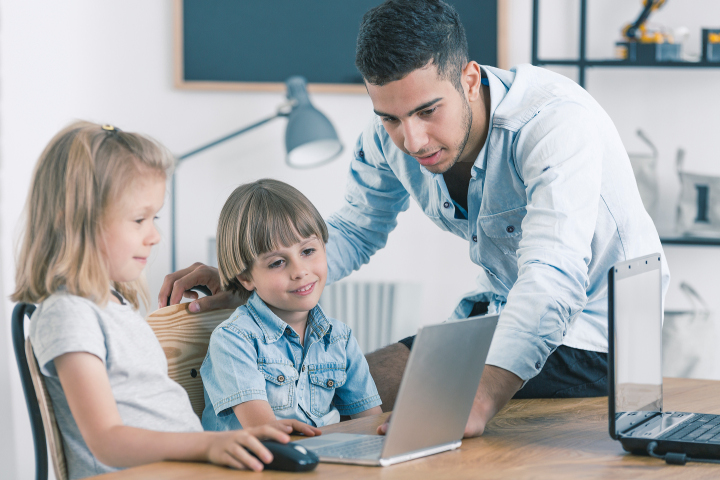 Fachkraft mit Kindern am Laptop