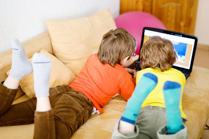 ThinkstockPhotos-669927002_romrodinka Original.jpg Zwei Jungs liegen auf dem Sofa und spielen am PC