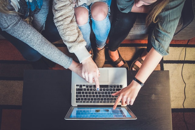 unsplash_John Schnobrich.jpg Menschen, die auf einen Laptopbildschirm zeigen.