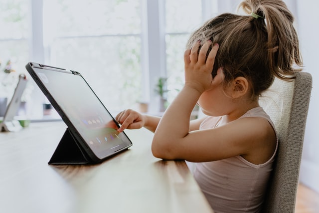 kelly-sikkema-CbZC2KVnK8s-unsplash.jpg Ein Kind, das ein Tablet bedient.