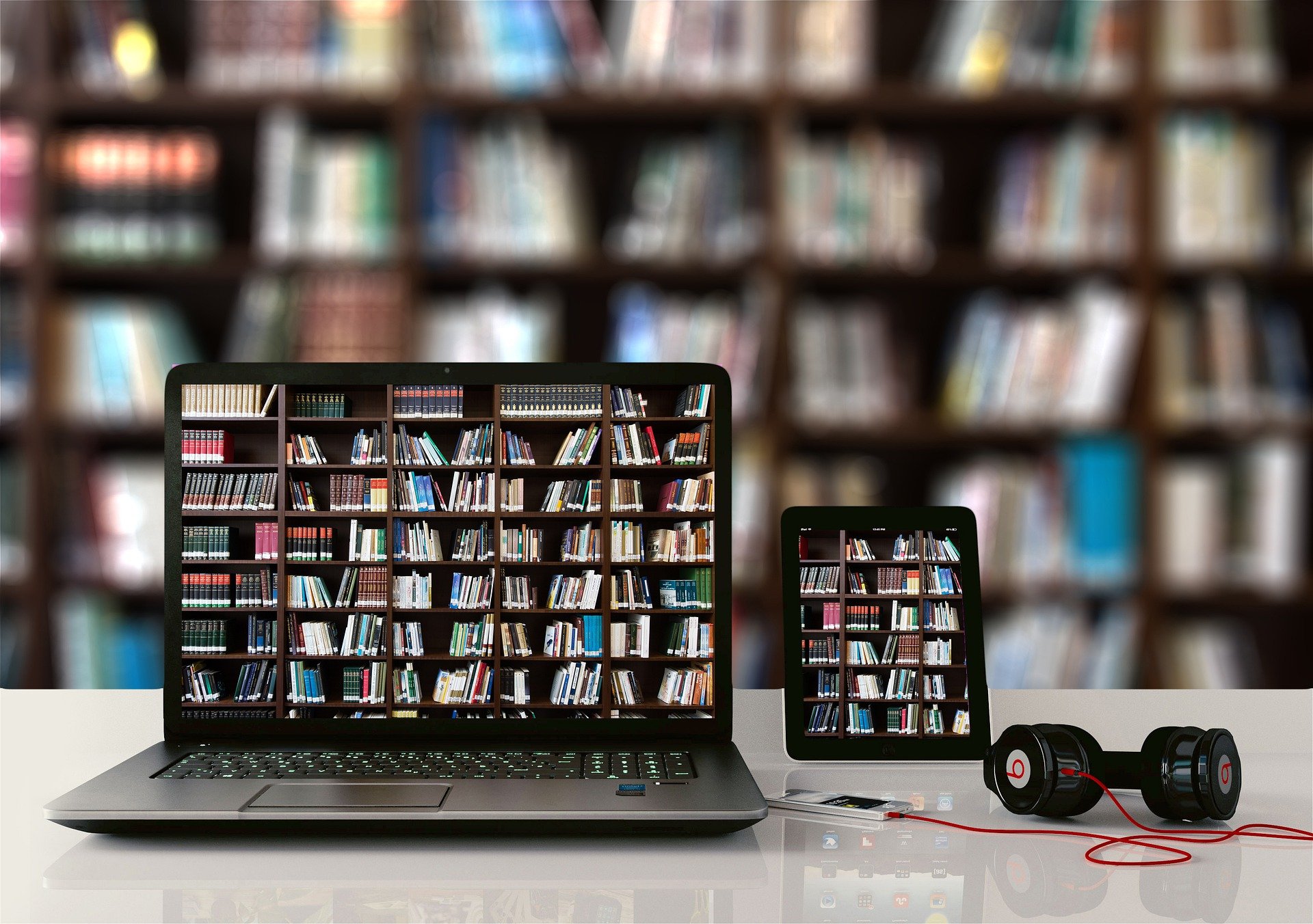 Digitale Endgeräte auf denen ein Bücherregal im Hintergrund zu sehen ist 