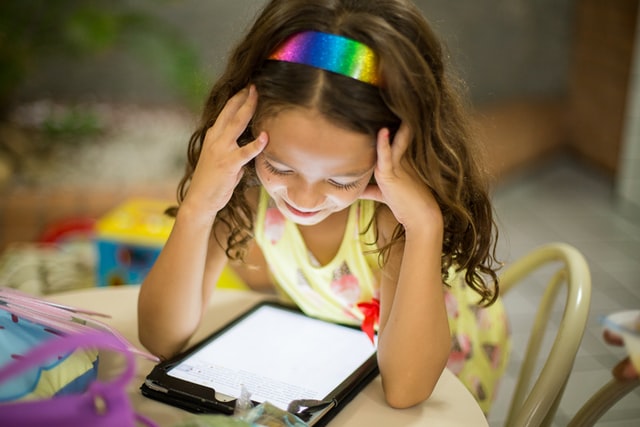 Ein Kind, welches auf ein Tablet schaut. 